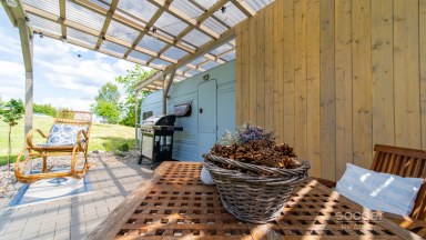 Příjemná venkovská zahrada s rekreačním karavanem a terasou.