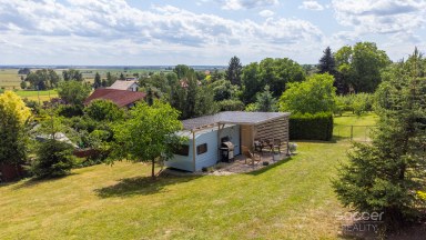 Příjemná venkovská zahrada s rekreačním karavanem a terasou.